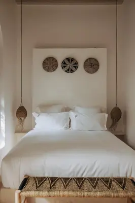 a bedroom with a large white bed with two baskets on the wall at Maison Dar Saada in Marrakech