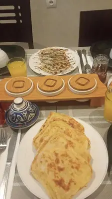 a table with a plate of pancakes on a table at Riad Taher Bed & Breakfast - Top position Médina in Marrakech