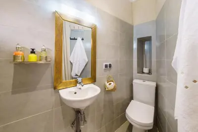 a bathroom with a sink and a mirror and a toilet at Riad Taher Bed & Breakfast - Top position Médina in Marrakech