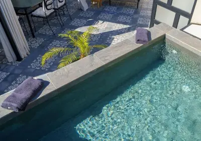 a swimming pool with two towels and a table and chairs at Riad Taher Bed & Breakfast - Top position Médina in Marrakech