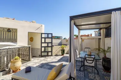 a patio with a table and chairs on a balcony at Riad Taher Bed & Breakfast - Top position Médina in Marrakech