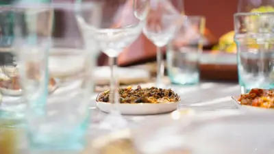 a table with wine glasses and a plate of food at Riad Anahata Marrakech in Marrakech