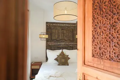 a bedroom with a bed with a large headboard at Riad Anahata Marrakech in Marrakech