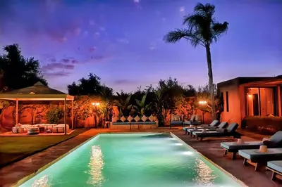 a swimming pool in a backyard at night at Domaine Homa Marrakech in Marrakech