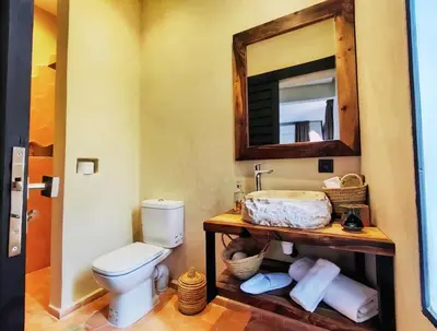 a bathroom with a toilet and a sink and a mirror at Domaine Homa Marrakech in Marrakech