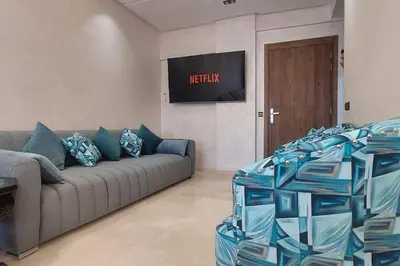 a living room with a couch and a television at Luxury city center apartment with swimming pool in Marrakech
