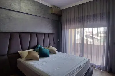 a bedroom with a large bed with a window at Luxury city center apartment with swimming pool in Marrakech