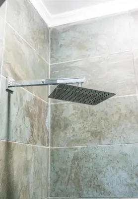 a shower with a steel rack in a bathroom at Riad LALLA JIHANE in Marrakech