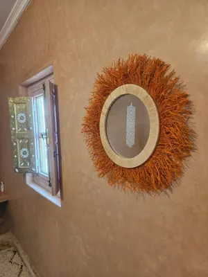 a circular mirror on a wall next to a window at Riad LALLA JIHANE in Marrakech