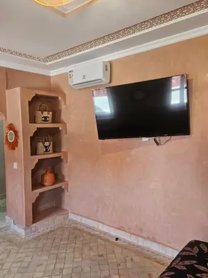 a flat screen tv hanging on a wall at Riad LALLA JIHANE in Marrakech