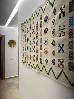 a wall with a quilt hanging on a wall at Premium Hivernage Amazigh 2BR Flat - Zayane Homes in Marrakech