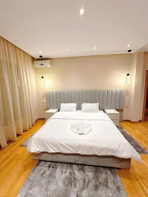 a bedroom with a large white bed with two tables at Villa Marrakech, 15 min from center, Disco, Hammam in Marrakech