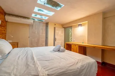 a bedroom with a large white bed with a skylight at Designer Villa in La Palmeraie Marrakech in Marrakech