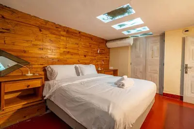 a bedroom with a white bed and a wooden wall at Designer Villa in La Palmeraie Marrakech in Marrakech