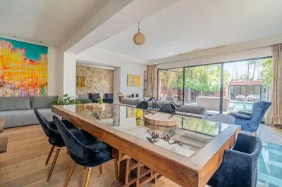 a living room with a large wooden table and chairs at Designer Villa in La Palmeraie Marrakech in Marrakech