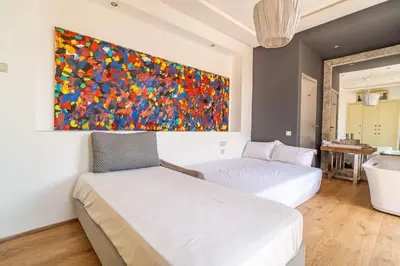 a bedroom with two beds and a painting on the wall at Designer Villa in La Palmeraie Marrakech in Marrakech