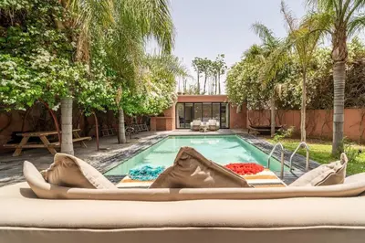 a pool with a large boat in front of a house at Designer Villa in La Palmeraie Marrakech in Marrakech
