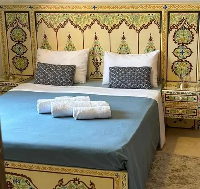 a bed with two towels sitting on top of it at À 6 min du stade - Résidence avec Piscine, Wifi, Gardien H24 in Marrakech