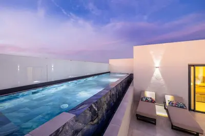 a swimming pool in a house with two chairs at Duplex piscine privée chauffée Rooftop in Marrakech