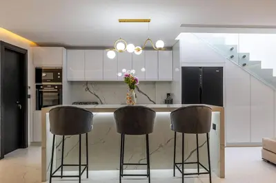 a kitchen with a island with chairs and a counter top at Duplex piscine privée chauffée Rooftop in Marrakech