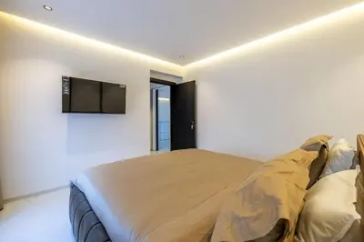 a bedroom with a large bed and a flat screen tv at Duplex piscine privée chauffée Rooftop in Marrakech