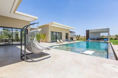 a house with a swimming pool with a whale sculpture at Villa luxueuse sans vis à vis - Piscine chauffée in Marrakech
