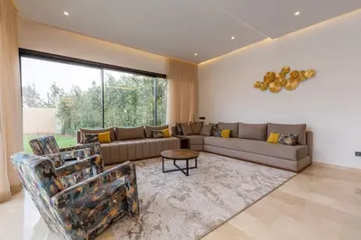 a living room with a couch and a table at Villa luxueuse sans vis à vis - Piscine chauffée in Marrakech