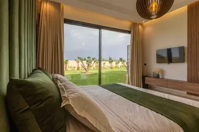 a bedroom with a large bed with a large window at Villa luxueuse sans vis à vis - Piscine chauffée in Marrakech