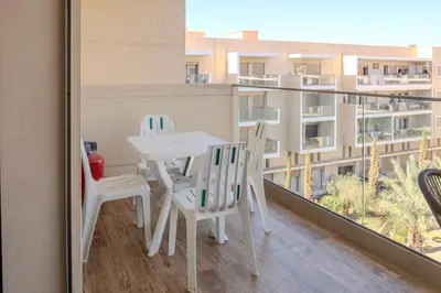 a table and chairs on a balcony with a view of a building at Oasis urbaine - Pearl Garden luxe et confort in Marrakech