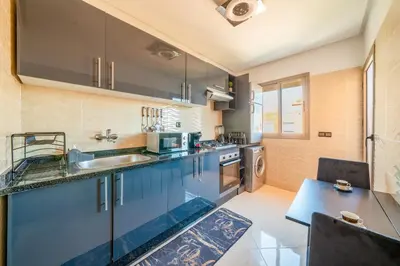 a large kitchen with blue cabinets and a sink at Cozy Studio with Mountain View in Gueliz, Marrakech in Marrakech