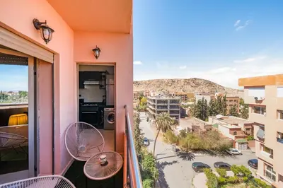 a balcony with tables and chairs and a view of a city at Cozy Studio with Mountain View in Gueliz, Marrakech in Marrakech