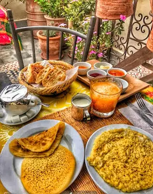 a table with plates of food on top of it at Hostel Dar Ben Youssef in Marrakech