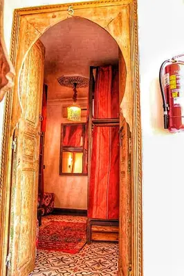 a hallway with an open door in a mirror at Hostel Dar Ben Youssef in Marrakech