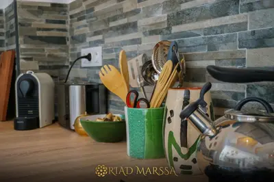 a kitchen counter with a cup filled with utensils at Riad Marssa, Privé Zen avec belle piscine dans la Médina in Marrakech