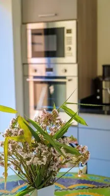 a vase of flowers on a table in a kitchen at Villa beldi chic Amelkis golf in Marrakech