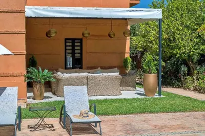 a patio with a table and chairs and a tent at Villa beldi chic Amelkis golf in Marrakech
