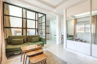 a living room with a green couch and a table at New! Chic studio, centrale Guéliz Carré Éden in Marrakech