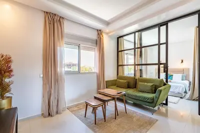 a living room with a green couch and a bed at New! Chic studio, centrale Guéliz Carré Éden in Marrakech