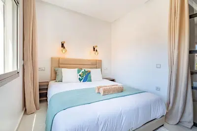 a bedroom with a large white bed with blue sheets at New! Chic studio, centrale Guéliz Carré Éden in Marrakech