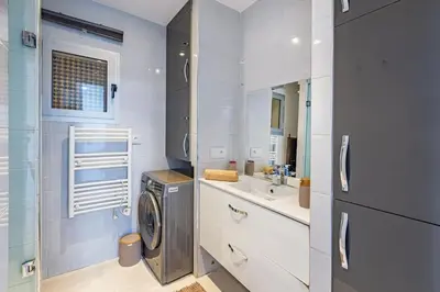 a white bathroom with a washing machine and a sink at New! Chic studio, centrale Guéliz Carré Éden in Marrakech