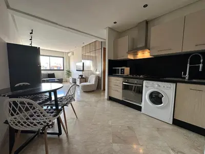 a kitchen with a washing machine and a table and chairs at Appartement chic et cosy en plein centre de Gueliz in Marrakech