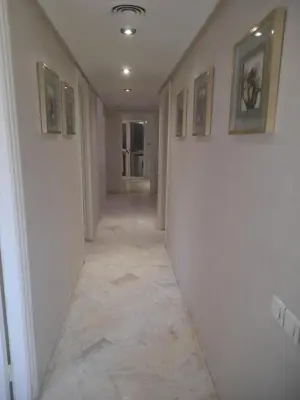 a hallway with white walls and a tile floor at App spacieux marrakech centre ville in Marrakech