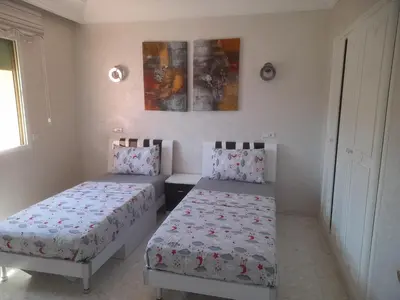 a bedroom with two beds and a window at App spacieux marrakech centre ville in Marrakech