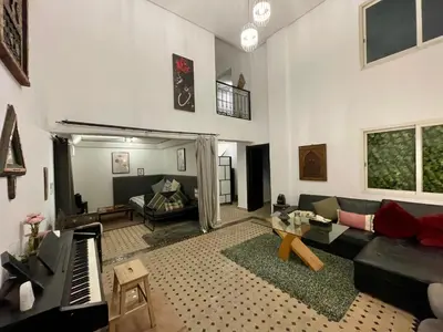 a living room with a couch and a piano at Au Riad Des Sultans - Marrakech in Marrakech