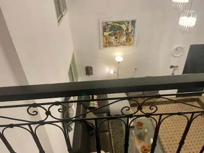 a balcony with a glass table and a painting at Au Riad Des Sultans - Marrakech in Marrakech