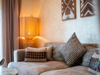 a living room with a couch with pillows on it at Magnifique appartement 3 chambres à Prestigia in Marrakech