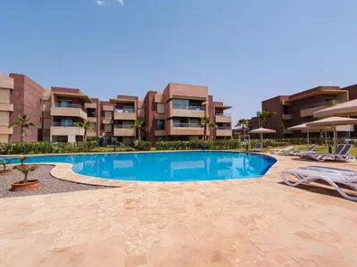 a swimming pool in front of a building at Magnifique appartement 3 chambres à Prestigia in Marrakech