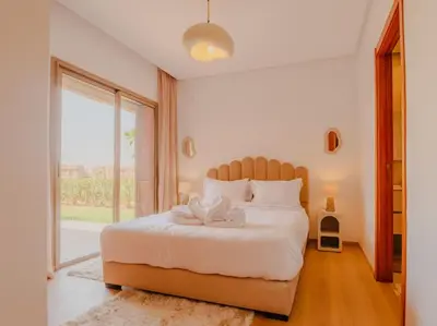 a bedroom with a large bed with a large window at Magnifique appartement 3 chambres à Prestigia in Marrakech