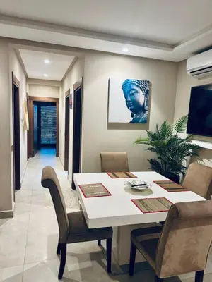 a dining room with a white table and chairs at Superbe appart au centre de gueliz in Marrakech
