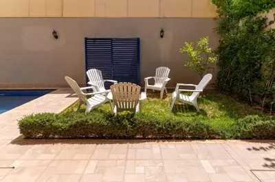a group of chairs and a table in the grass at Peaceful Marrakech Villa 4 Bedrooms Private Pool in Marrakech